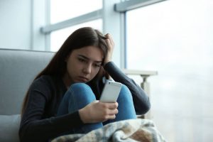 How-Does-Social-Media-Affect-Teens-1024×683 High school students sitting on a bench on their laptops